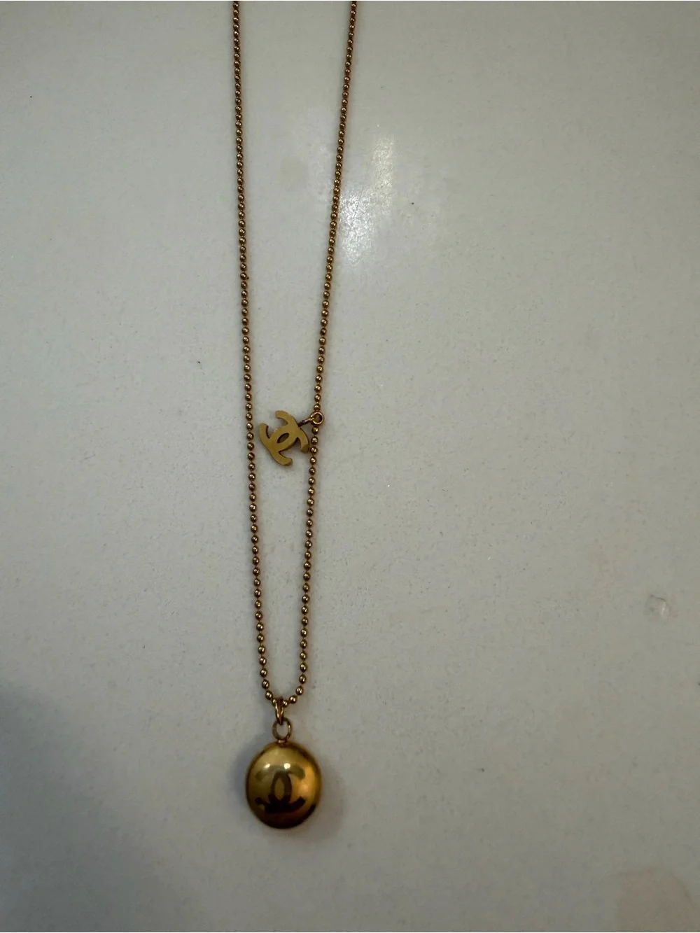 CHANEL Gold Tone Layered Necklace with Round Pendant and Logo Charm